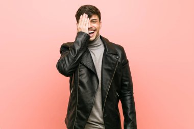 Deri ceket giyen genç İspanyol, yüzünün yarısını palmiye ile kaplayarak eğleniyor..