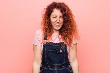 Kot pantolon giyen kızıl saçlı genç bir kadın güler, gözlerini kapatır, rahatlar ve mutlu olur..