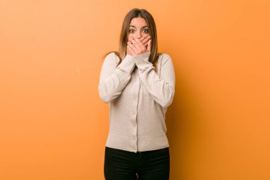 Genç otantik karizmatik gerçek insanlar kadın bir duvara karşı elleri ile ağız kapsayan şok.