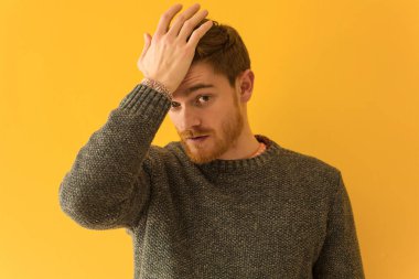 Genç kızıl saçlı adamın yüzü endişeli ve bunalmış.