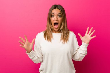 Bir zafer ya da başarı kutlayan bir duvara karşı Genç otantik karizmatik gerçek insanlar kadın, o şaşırır ve şok.