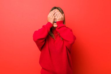 Genç, otantik, karizmatik bir kadın. Duvara yaslanmış gerçek bir kadın. Gözleri ellerle kaplıyor..