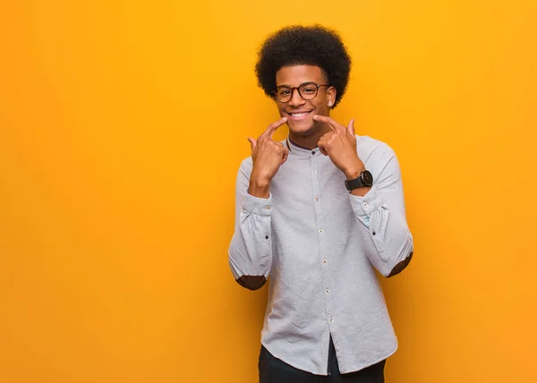 Jovem Afro Americano Sobre Uma Parede Laranja Sorri Apontando Boca — Fotografia de Stock