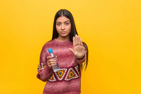 Молода Арабська Жінка Тримає Пляшку Води Стоїть Простягнутою Рукою Показуючи — стокове фото