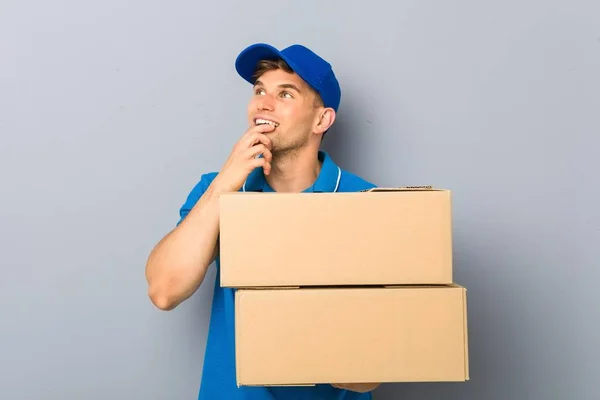 Young Man Delivering Packages Relaxed Thinking Something Looking Copy Space — Stok fotoğraf