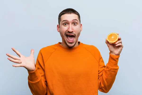 Jeune Homme Caucasien Tenant Une Orange Célébrant Une Victoire Succès — Photo