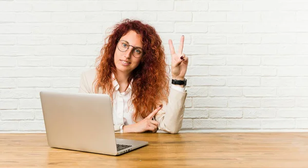 Mladá Zrzka Kudrnatá Žena Pracující Svým Notebookem Ukazující Číslo Dvě — Stock fotografie