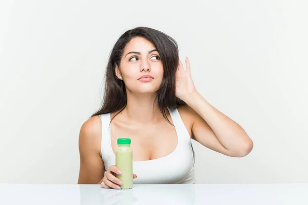 Mujer Hispana Joven Sosteniendo Una Bebida Vegetal Tratando Escuchar Chisme —  Fotos de Stock