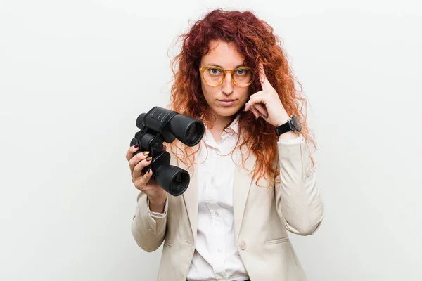 Joven Mujer Pelirroja Negocios Caucásica Sosteniendo Prismáticos Apuntando Sien Con —  Fotos de Stock