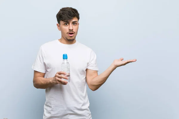 Jonge Spaanse Man Met Een Fles Water Onder Indruk Houden — Stockfoto