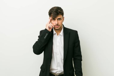Genç bir İspanyol işadamı şakağı parmağıyla işaret ediyor, düşünüyor, bir göreve odaklanıyor..