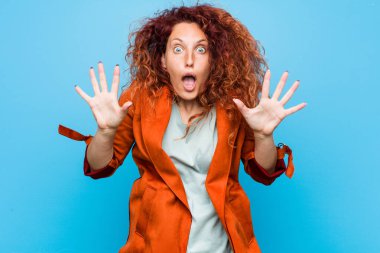 Genç kızıl saçlı zarif kadın zaferi ya da başarıyı kutluyor, şaşırdı ve şok oldu..