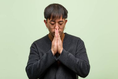 Yeşil duvara karşı genç Çinli adam