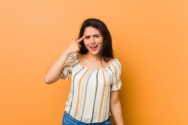 Genç kıvrımlı kadın işaret parmağıyla hayal kırıklığı gösteriyor..