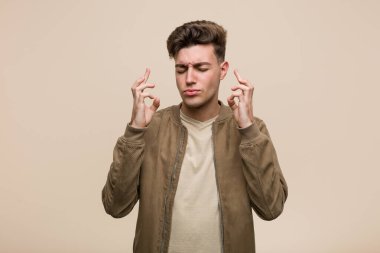 Kahverengi ceketli genç beyaz adam şans dilemek için şans diliyor.