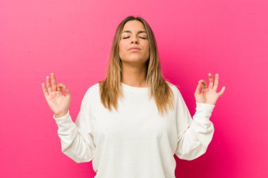 Bir duvara karşı Genç otantik karizmatik gerçek insanlar kadın zor iş gününden sonra rahatlatır, o yoga yapıyor.