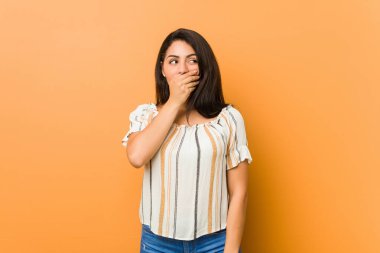 Genç kıvrımlı kadın bir fotokopi odasına dikkatlice bakıyor. Ağzını eliyle kapatıyor..