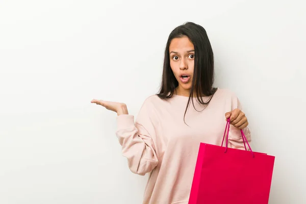 Ung Latinamerikansk Kvinna Håller Shoppingväska Imponerad Hålla Kopia Utrymme Handflatan — Stockfoto