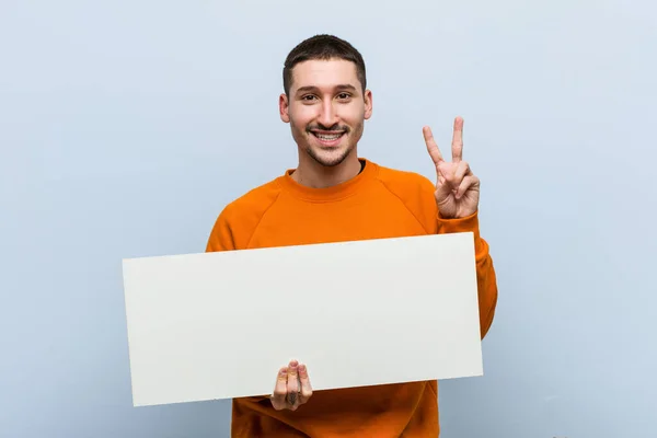 Joven Caucásico Sosteniendo Cartel Que Muestra Número Dos Con Los — Foto de Stock