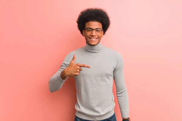 年轻的非洲裔美国人穿过粉红的墙壁 手拉手指着衬衫的复制品 自豪而自信 — 图库照片