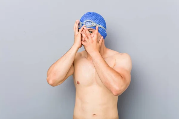 Junger Berufsschwimmer Blinzelt Verängstigt Und Nervös Durch Die Finger — Stockfoto