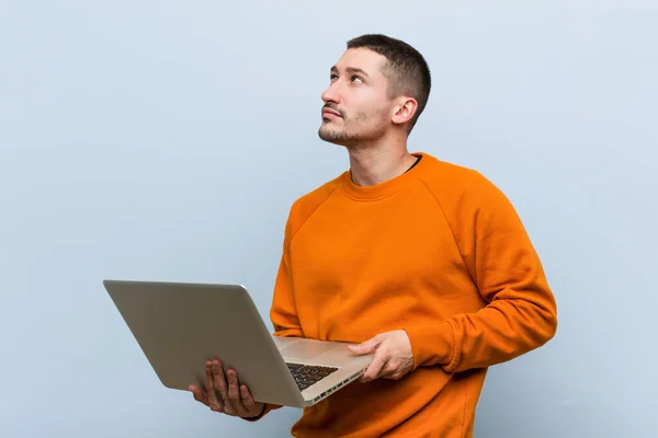 Jovem Caucasiano Segurando Laptop Sorrindo Confiante Com Braços Cruzados — Fotografia de Stock