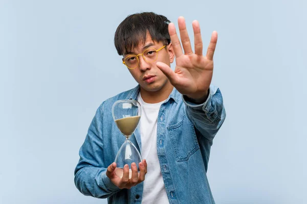 Young Chinese Man Holding Sand Timer Putting Hand Front — Stock Photo, Image