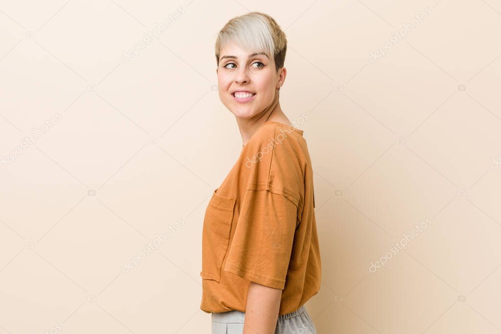 Young plus size woman with short hair looks aside smiling, cheerful and pleasant.