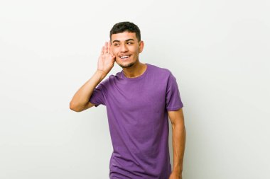 Genç İspanyol adam bir dedikodu dinlemeye çalışıyor.