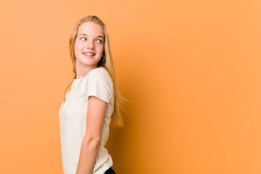 Sevimli ve doğal genç bir kadın gülümseyen, neşeli ve hoş bir şekilde yana bakar..