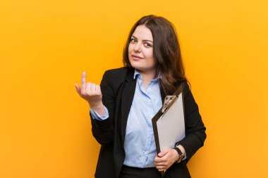 Genç ve cüsseli bir iş kadını elinde bir panoyla seni işaret ediyor. Sanki seni davet ediyormuş gibi..