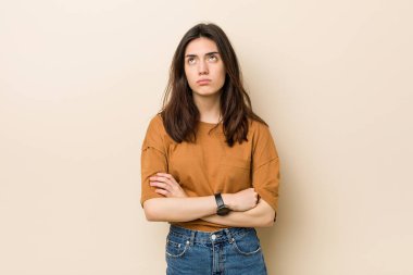 Bej arka planda genç esmer kadın tekrarlanan bir görevden yoruldu..