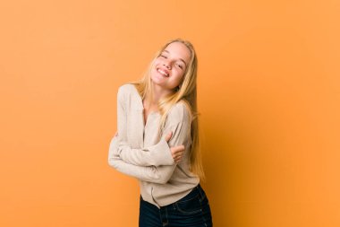 Sevimli beyaz genç turuncu bir arka planda ayakta poz