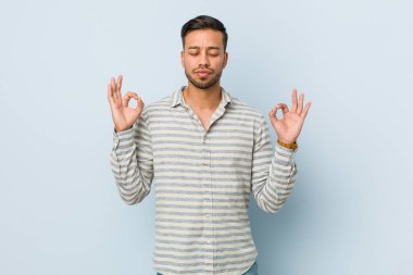 Genç ve yakışıklı Filipinli adam yorucu bir günün ardından rahatlıyor. Yoga yapıyor..