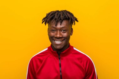 Sarı bir arka plan aleyhine duran genç bir Afrikalı sportif adam yakın çekim