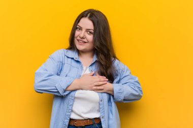 Genç, kıvrımlı, iri yarı bir kadının, avuçlarını göğsüne bastıran dostça bir ifadesi var. Aşk konsepti.