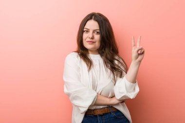 Pembe arka planda Genç beyaz Curvy kadın ayakta