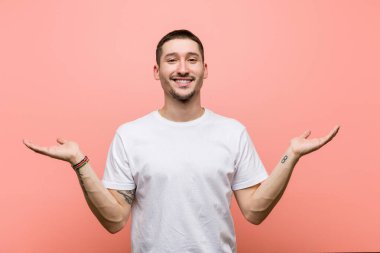 Genç adam kollarıyla ölçeği yapıyor, mutlu ve kendinden emin hissediyor..