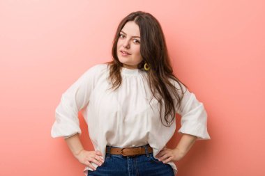 Pembe arka planda Genç beyaz Curvy kadın ayakta