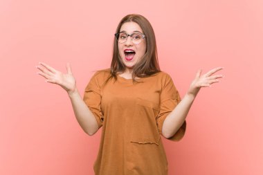 Zaferi ya da başarıyı kutlayan gözlüklü genç bayan öğrenci şaşırdı ve şok oldu..