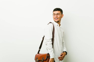 Genç İspanyol sıradan iş adamı gülümseyen, neşeli ve keyifli bir şekilde yana bakıyor..