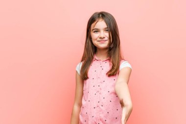 Sevimli küçük kız kameraya elini uzatıp selam veriyor..