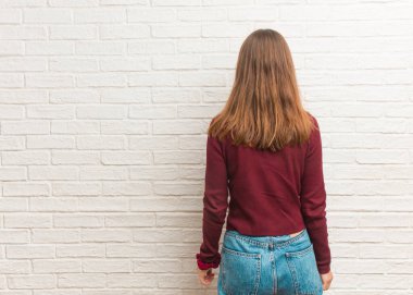 Duvarın arkasında arkasını kollayan havalı genç bir kadın.