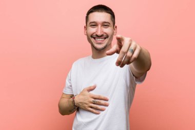 Genç adam başparmağıyla işaret ediyor, gülüyor ve kaygısız..