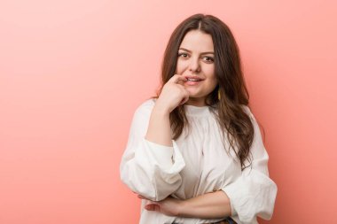 Pembe arka planda Genç beyaz Curvy kadın ayakta