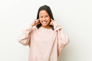 Genç, tatlı İspanyol kadın elleriyle kulaklarını kapatıyor..