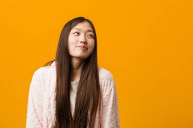 Pijamalı genç Çinli kadın amaçlarına ve amaçlarına ulaşmayı hayal ediyor.