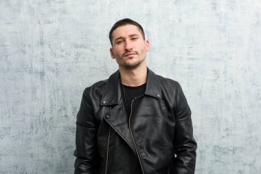 Deri ceket giyen grunge arka plan karşı duran genç beyaz adam