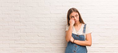 Genç hippi kadın bir şeyler düşünüyor, yana bakıyor.