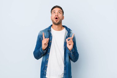 Genç yakışıklı Filipinli adam ağzı açık bir şekilde yukarı bakıyor..